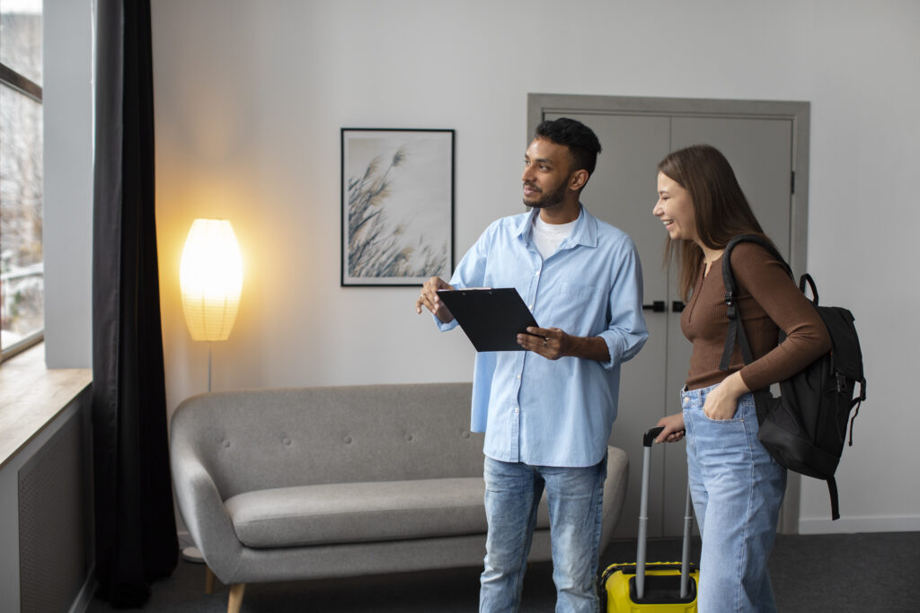 Homme et femme discutant dans un salon avec une valise jaune