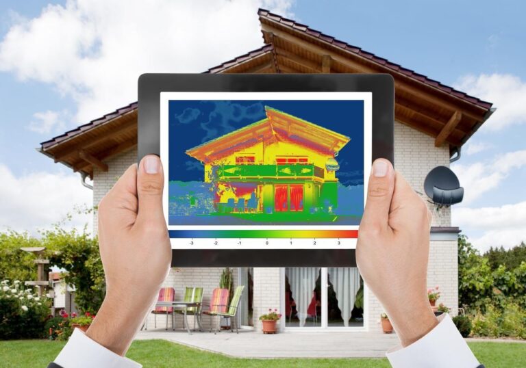 Analyse thermique d’une maison à l’aide d’une tablette affichant une image en thermographie.