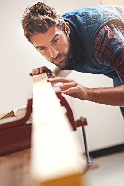 Carpenter, wood and design with man in workshop for building, manufacturing and creative. Planning, industry and woodworker with handyman measuring on workbench for builder, lumber and maintenance.