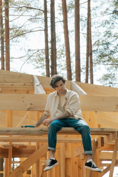 charpentier homme assis sur des planches de vois dans une fprêt forêt